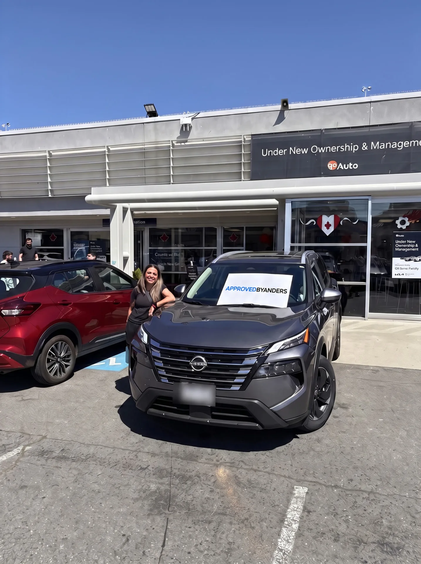 Woman with her grey Nissan Rogue at the Go Auto store